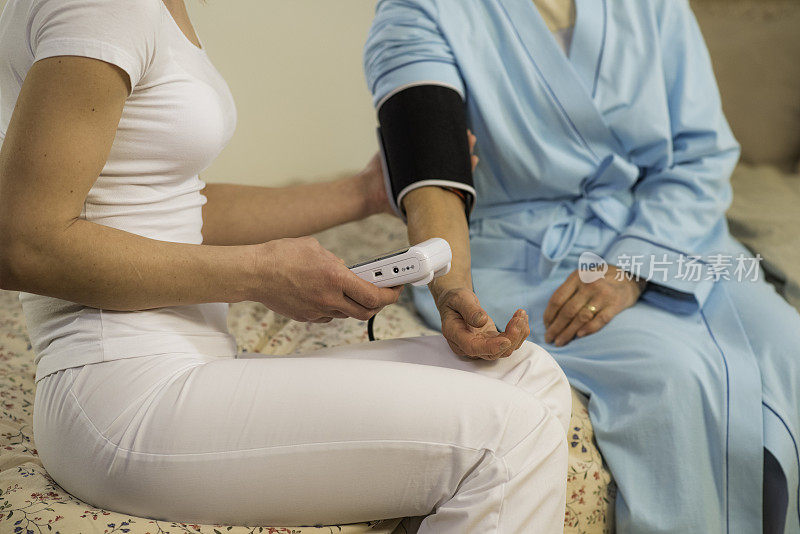 家庭保健护士为老年妇女检查血压