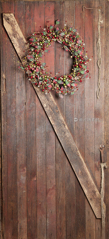 圣诞花环挂在旧谷仓的木头门上