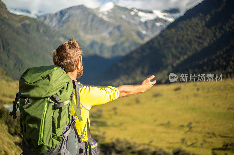 日出时分，一名男子站在山顶，双臂张开