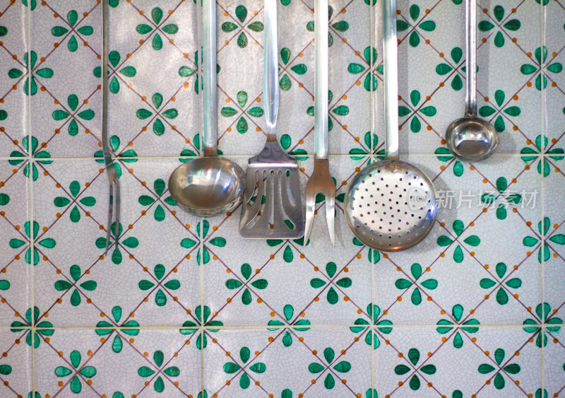 挂在意大利瓷砖上的金属厨房用具