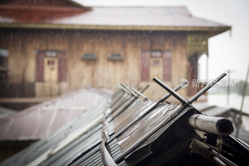 缅甸，雨水倾泻在竹屋顶上。