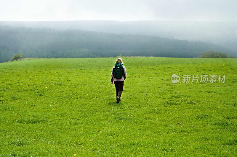 英国雾气弥漫的北约克郡荒原上的女徒步旅行者