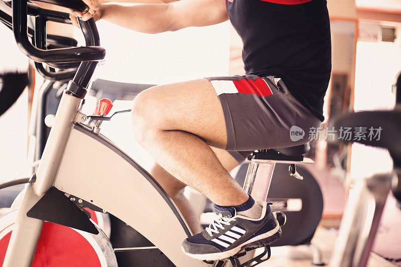 男性在健身房里骑自行车锻炼肌肉