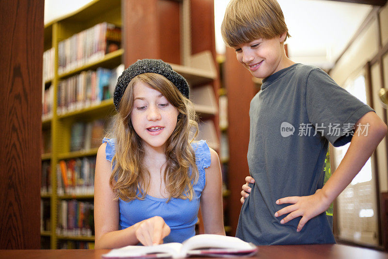 女孩在图书馆给男孩读故事