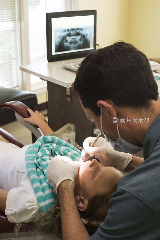 牙医检查一个白人女孩的牙齿