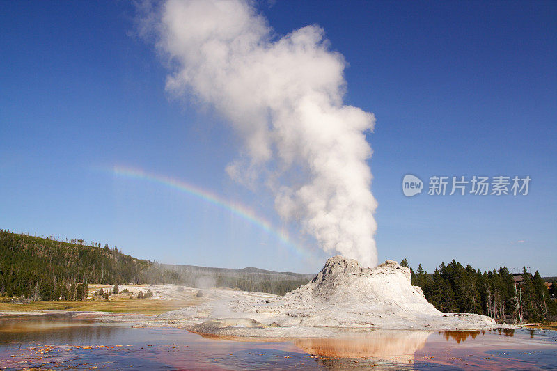 城堡间歇泉与白色的烟雾和彩虹天空的背景