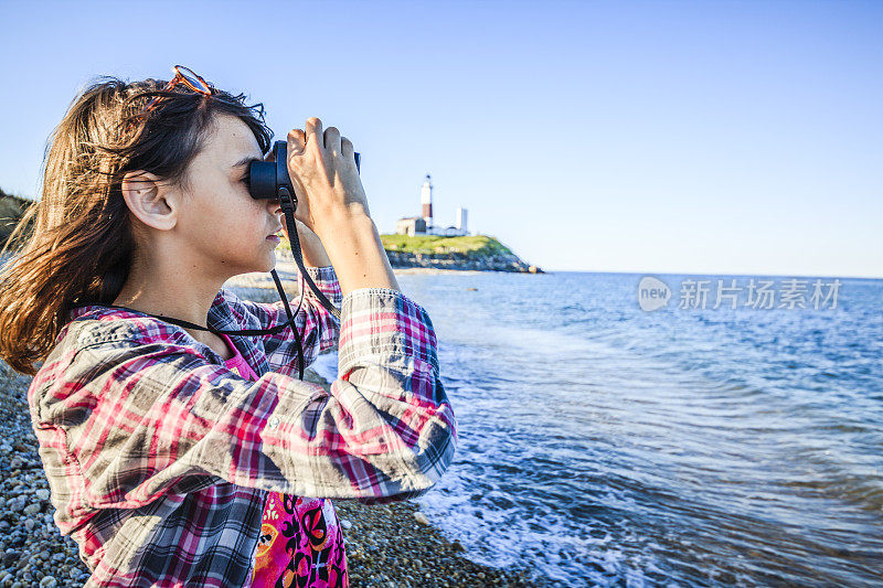 少女用双筒望远镜探索海洋