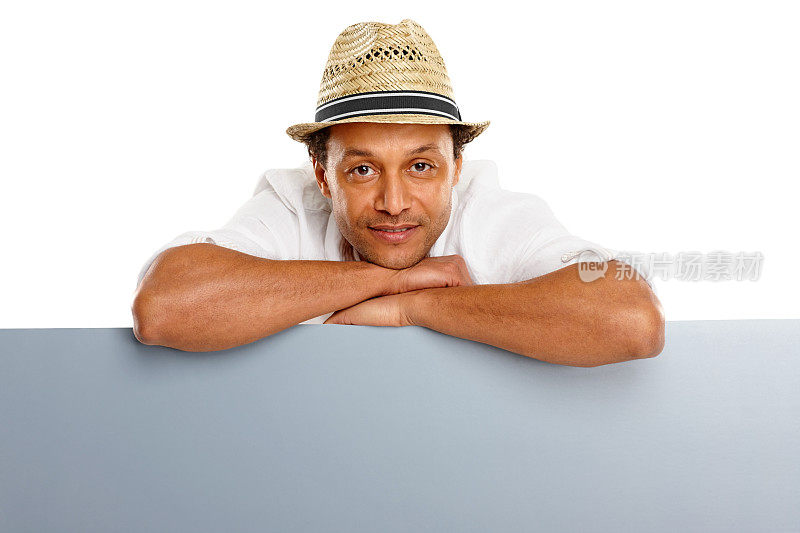 轻松成熟的男人靠在空白的广告牌上