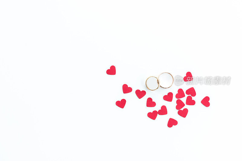 顶视图的黄金结婚戒指和粉红色的心符号孤立在白色，结婚戒指的背景