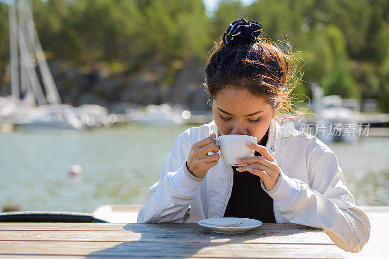 年轻美丽的亚洲女人放松对码头的看法