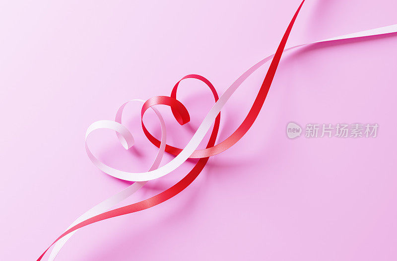 情人节卡片-心形丝带纠结在粉红色的背景
