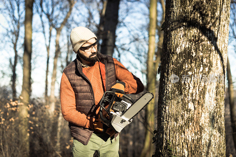 伐木工人带着工作工具-链锯和防护服