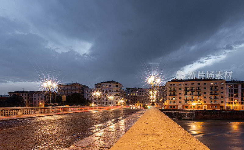 意大利维罗纳阿迪杰河上的维多利亚桥，夜间交通繁忙