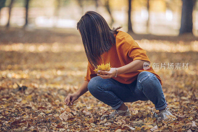 美丽的女人在秋天的公园