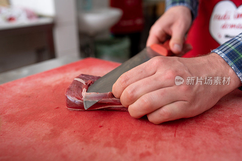 男厨师正在切一大块牛肉