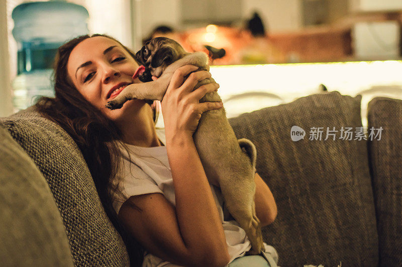 一个年轻女人和一只哈巴狗坐在客厅里