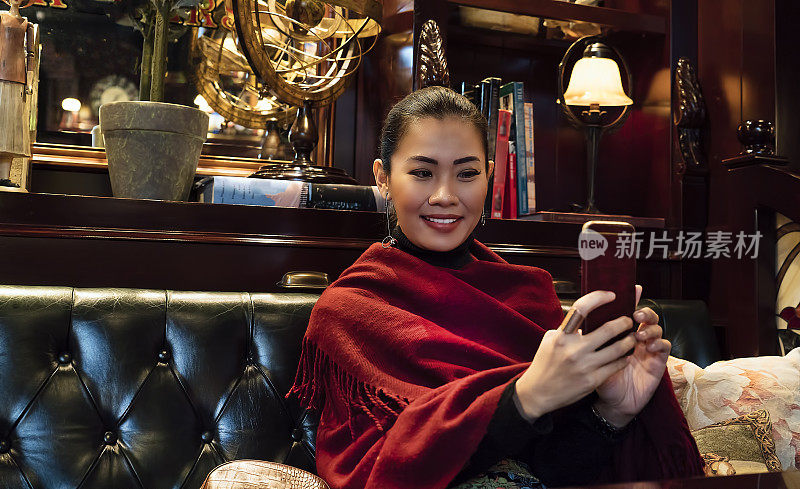 在一家豪华餐厅用手机相机自拍的亚洲女人