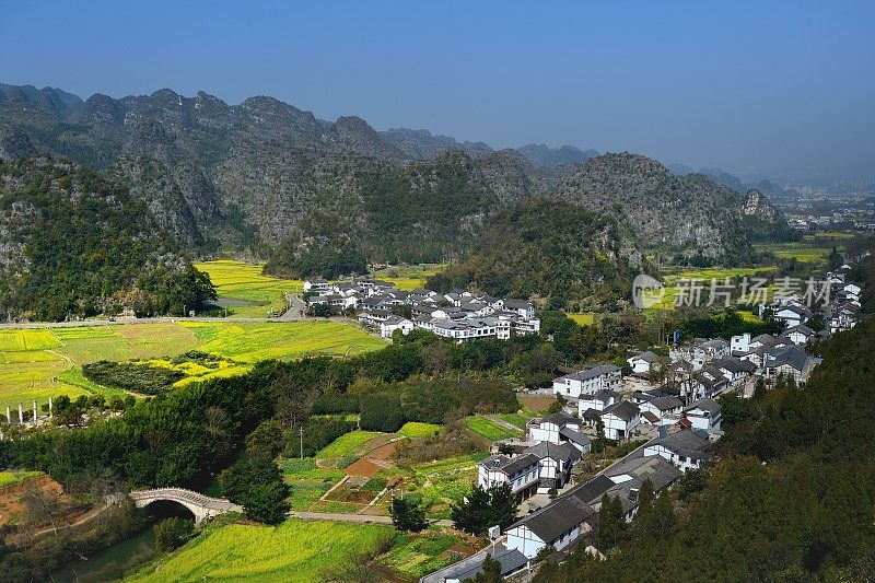 村和油菜花田在喀斯特山峰森林