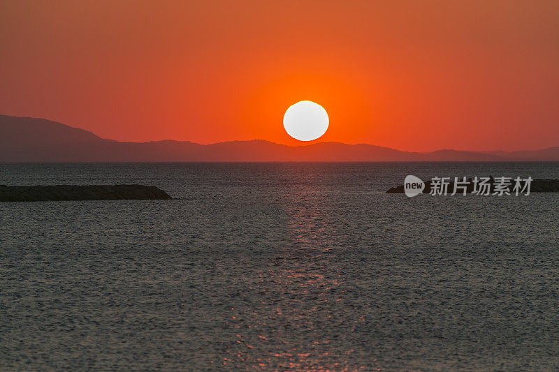 日落时分，土耳其阿瓦利克巴利克西尔阿尔蒂诺瓦夏日小镇的海滩海岸