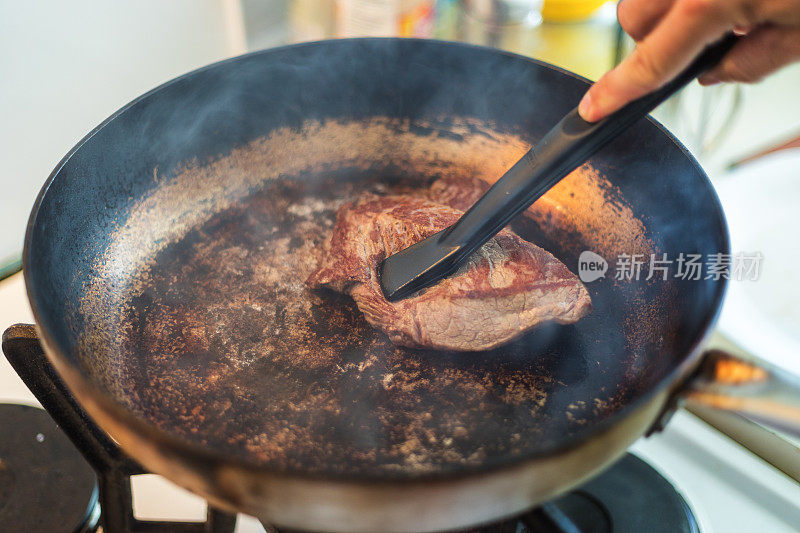 臀部牛排在平底锅里烤，特写