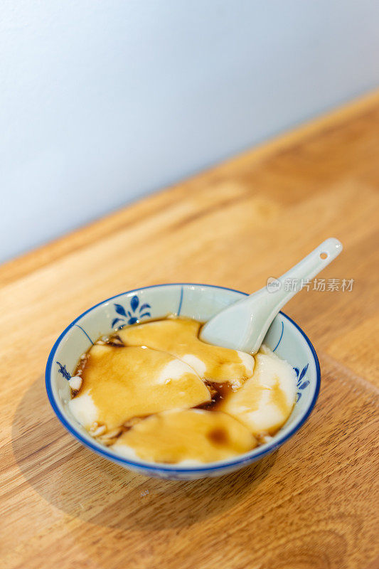 豆腐布丁配红糖糖浆放在木桌上