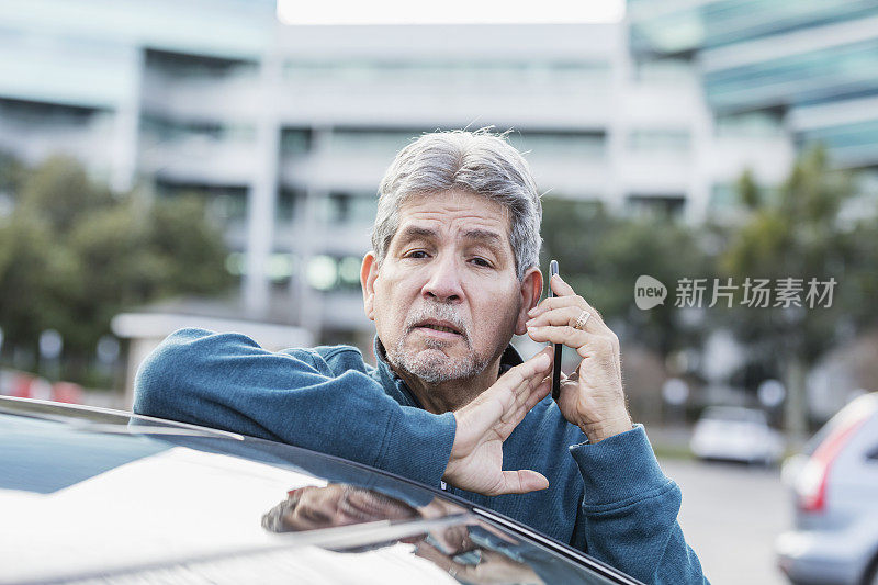 西班牙裔老人靠在车上，手机上