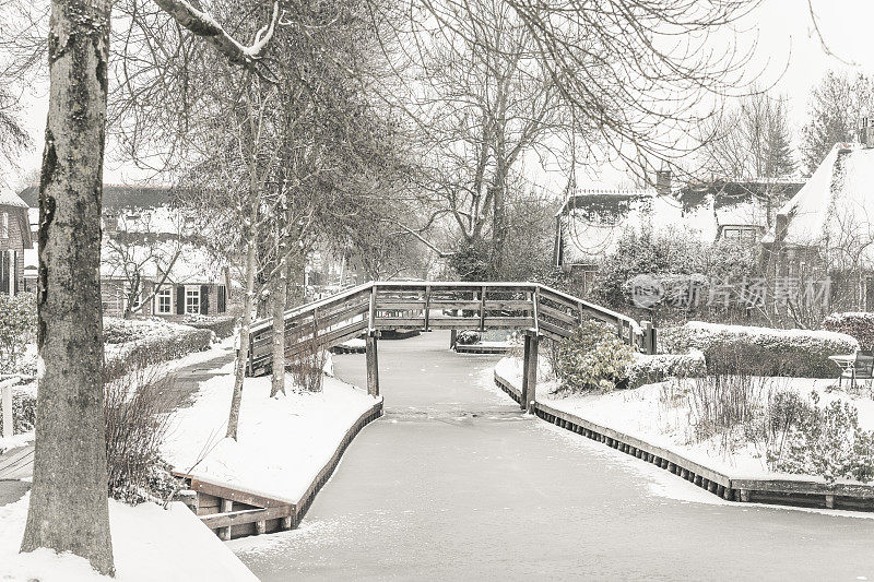 在一个寒冷但美丽而平静的冬天，Giethoorn村的运河和积雪