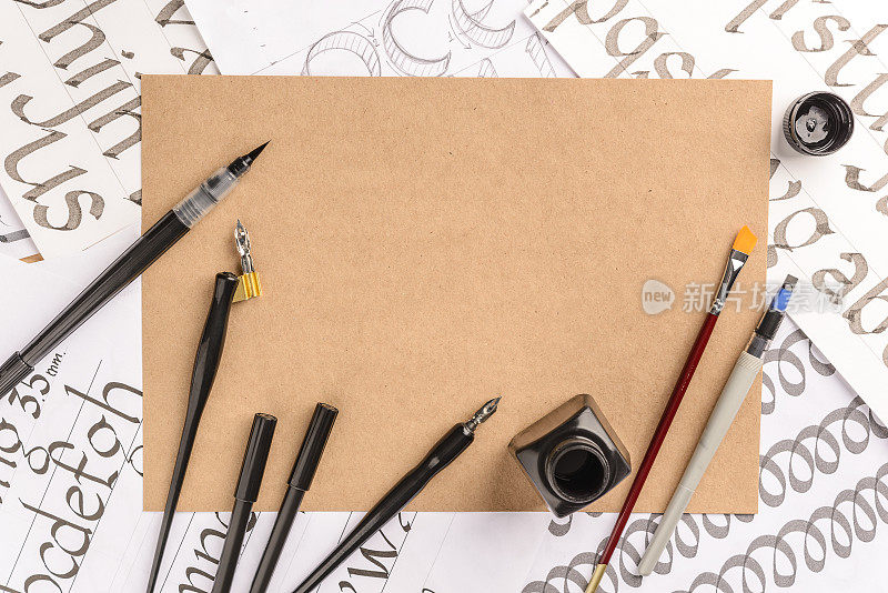 书法概念，配件和工具的书写，墨水，毛笔，书写训练，空白纸白纸和纸板手工制作在木桌上，放置文字