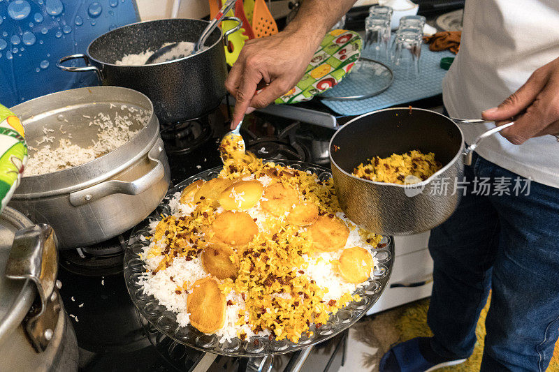 成熟的男人在家庭厨房烹饪传统的伊朗饭，米饭和蔬菜