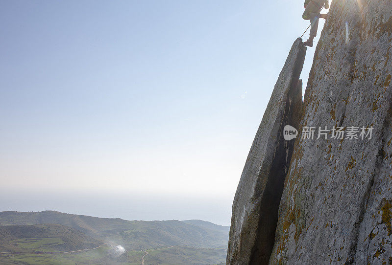 登山者在日出时攀登岩面