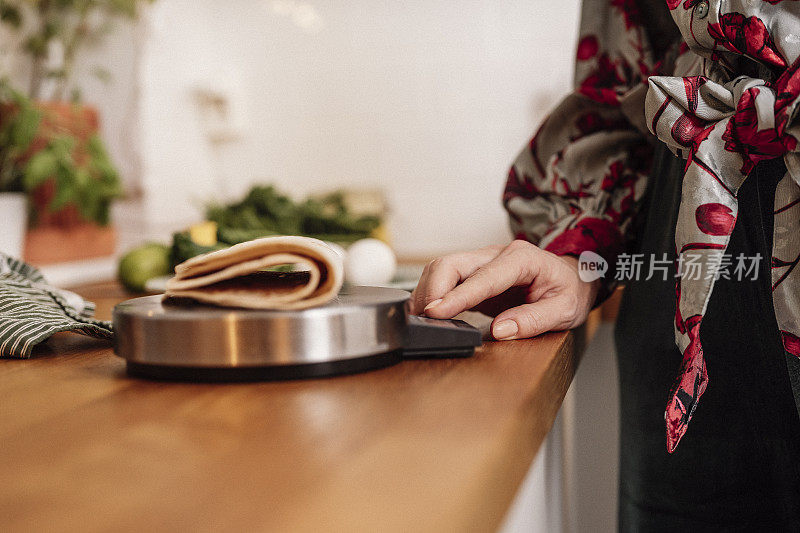 妇女称重她的食物计算热量饮食