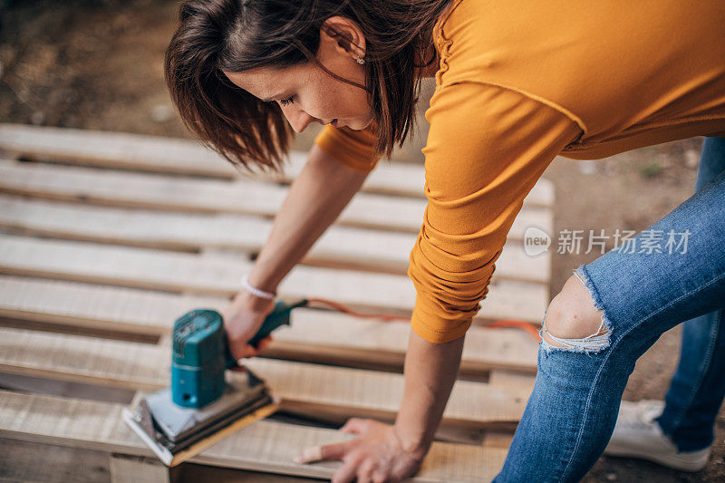 女士在建筑工地上刮木板