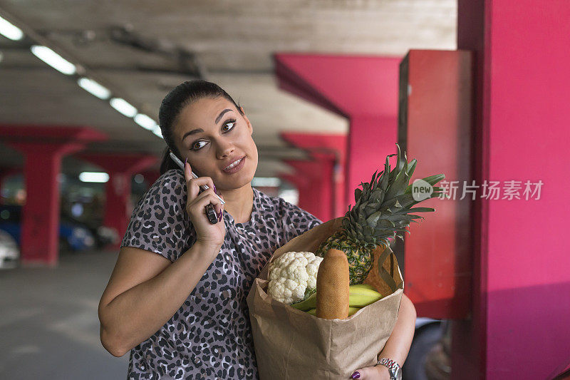 拿着购物袋打电话的女人