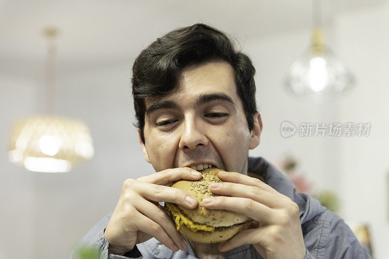 一个吃汉堡包的年轻人的肖像