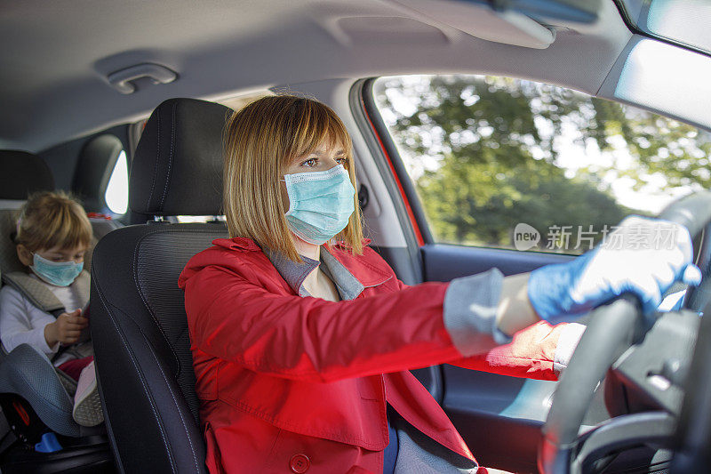 一个女人开车，后座上坐着一个小女孩