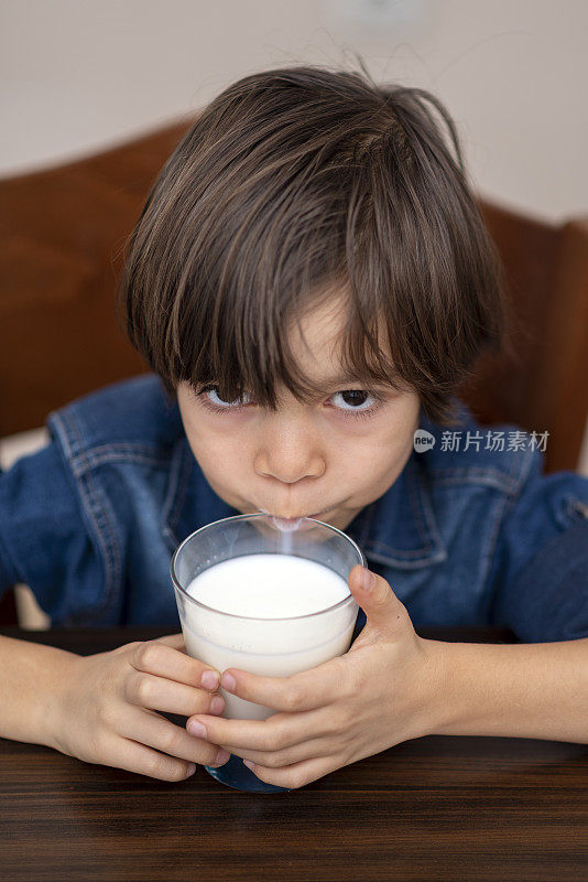 无聊的孩子在家喝牛奶
