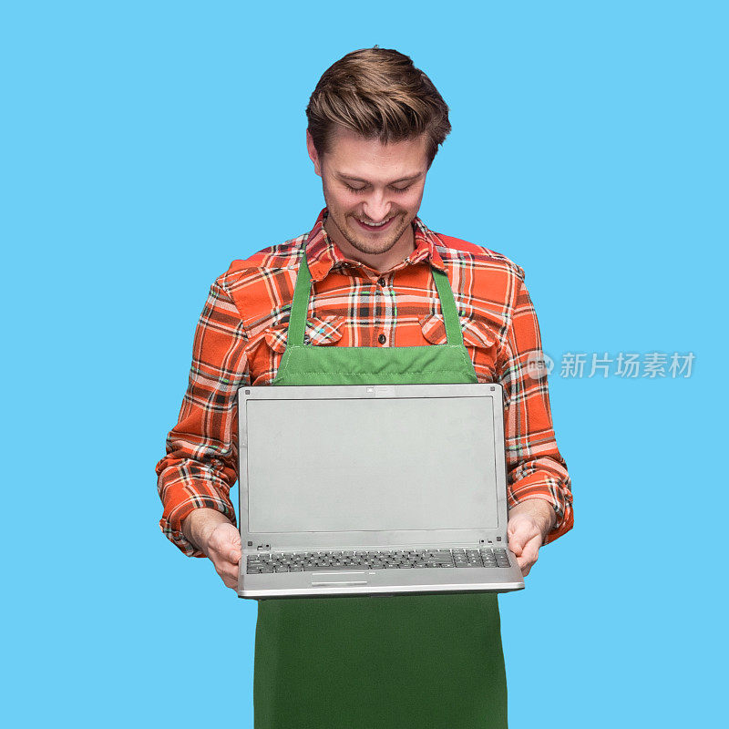 白人男咖啡师穿着伐木工衬衫站着用笔记本电脑