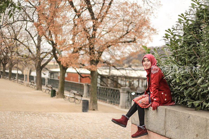在布拉格伏尔塔瓦河边，亚洲戴头巾的游客享受秋天