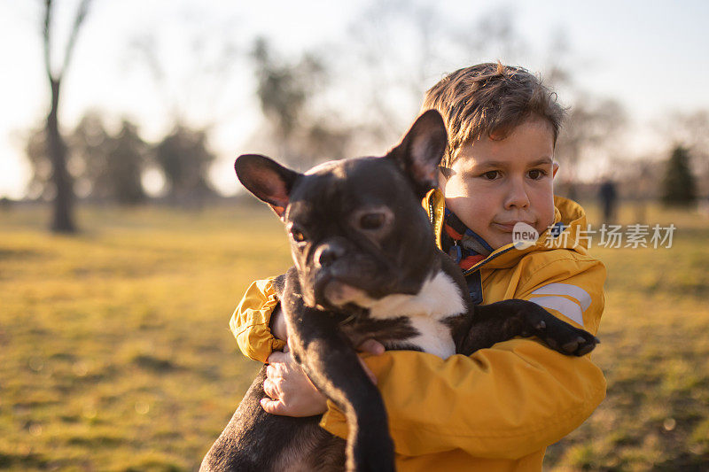 一个可爱的男孩抱着一只狗做鬼脸