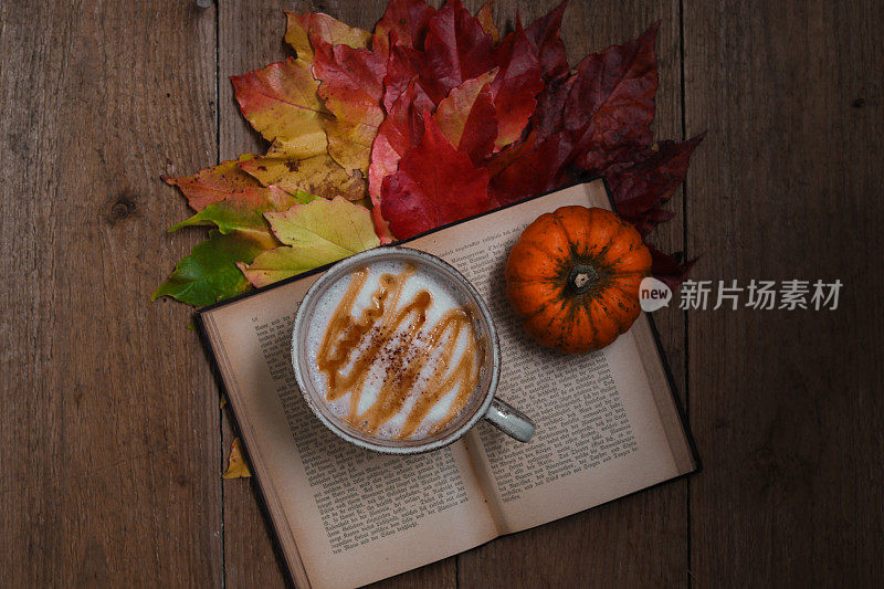 秋天的静物杯和彩色的枯叶在木板上