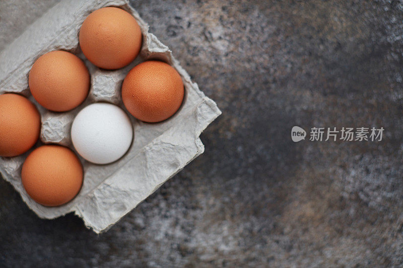 硬纸板鸡蛋盒里的棕色和白色鸡蛋的静物图像