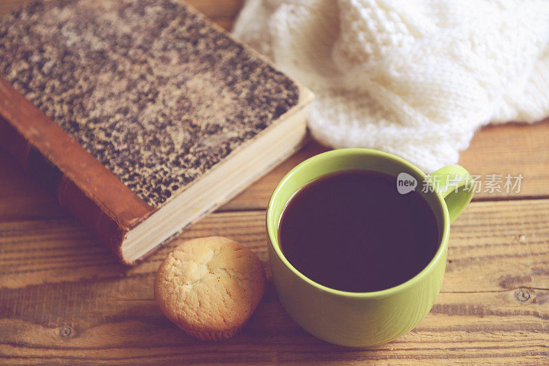 木桌上放着旧书和咖啡