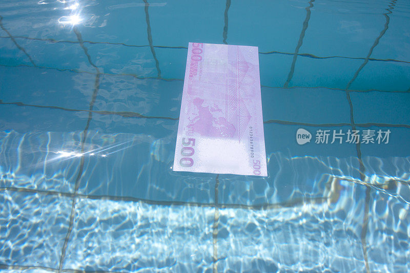 500欧元纸币在清澈的蓝色海水上游泳