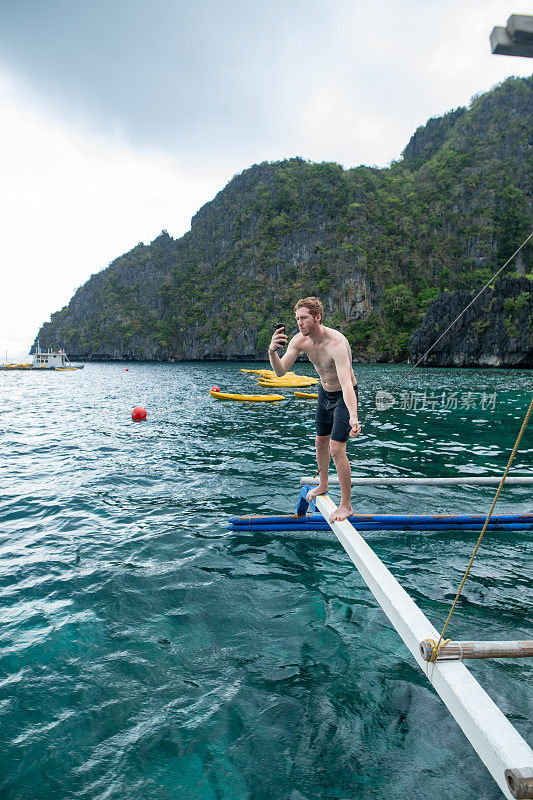 一名千禧一代男子在菲律宾乘船游览时用手机自拍