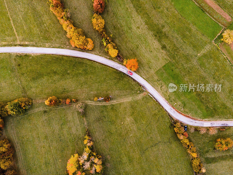 秋天里，汽车在蜿蜒的单车道乡村道路上从上往下行驶