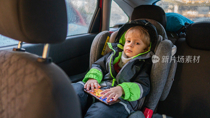 幼儿将安全带系在高靠背加高的汽车座椅上。孩子的安全。