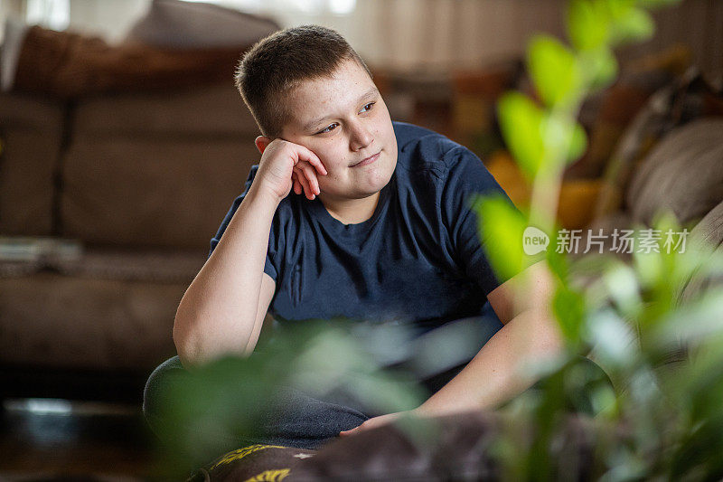 一个十几岁男孩坐在家里的肖像