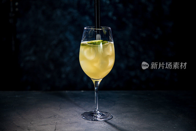 黄色鸡尾酒加酸橙，黑吸管