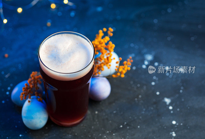 限量版精酿啤酒杯，蓝色背景，画上复活节彩蛋。庆祝复活节的概念，复制空间