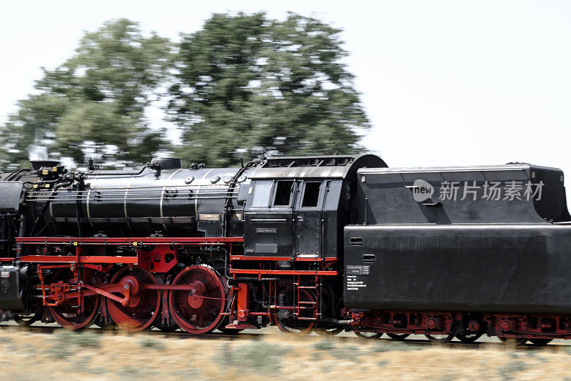 古老的蒸汽火车拖着火车车厢在乡间行驶